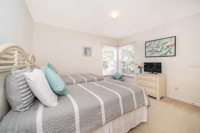 bedroom featuring baseboards and light colored carpet