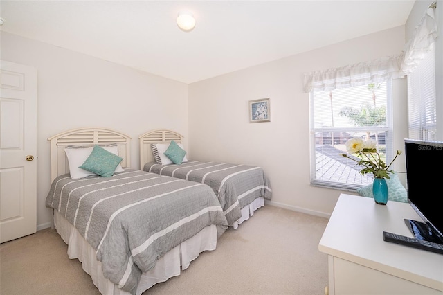 bedroom featuring baseboards and light carpet