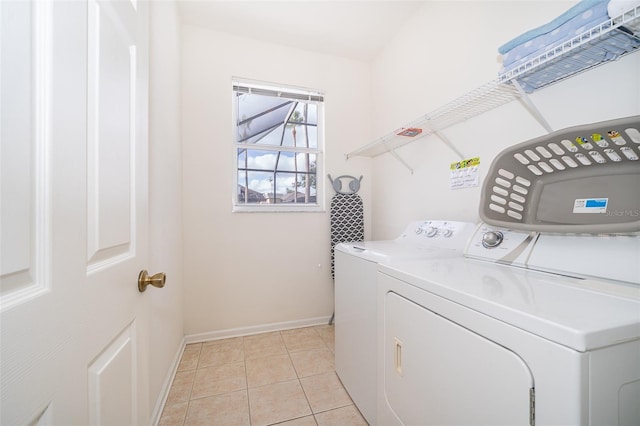 laundry area with laundry area, baseboards, independent washer and dryer, and light tile patterned floors