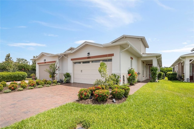 ranch-style home featuring an attached garage, a front yard, decorative driveway, and stucco siding