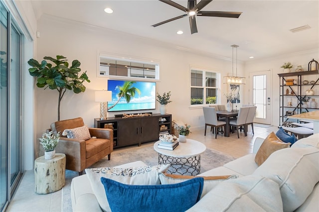 living room with recessed lighting, ornamental molding, ceiling fan with notable chandelier, visible vents, and light tile patterned flooring