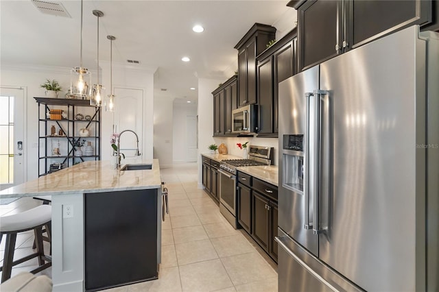 kitchen with high quality appliances, a sink, visible vents, crown molding, and a center island with sink