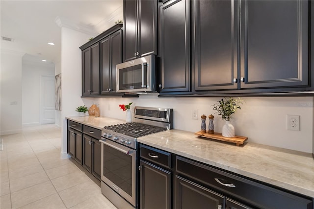 kitchen with recessed lighting, light stone counters, stainless steel appliances, ornamental molding, and light tile patterned flooring