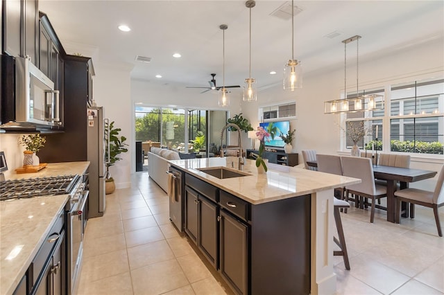 kitchen featuring appliances with stainless steel finishes, ceiling fan, a sink, visible vents, and open floor plan