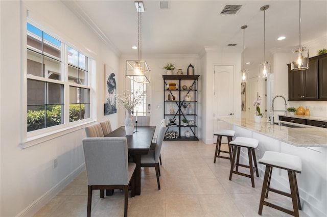 dining space featuring baseboards, visible vents, and ornamental molding