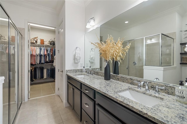 bathroom with tile patterned flooring, ornamental molding, a stall shower, and a sink