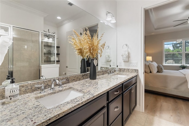 ensuite bathroom featuring crown molding, a ceiling fan, a sink, and visible vents