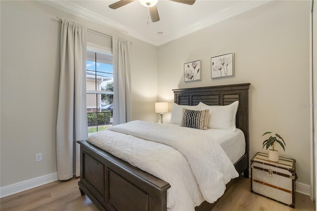 bedroom featuring baseboards, light wood-type flooring, ceiling fan, and crown molding