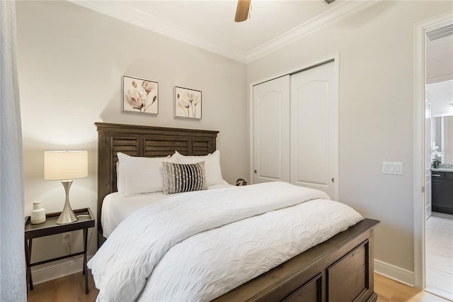bedroom featuring a closet, ceiling fan, light wood-style flooring, baseboards, and ornamental molding