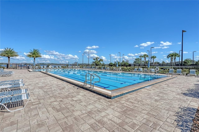community pool featuring fence and a patio
