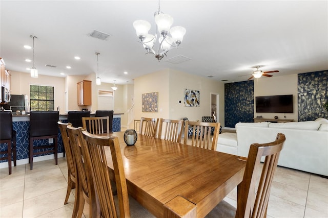 dining area with light tile patterned floors, visible vents, and ceiling fan with notable chandelier