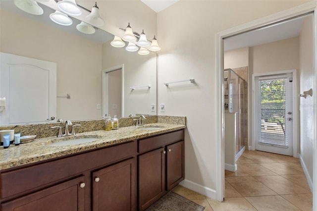 full bath featuring tile patterned floors, a shower stall, baseboards, and a sink