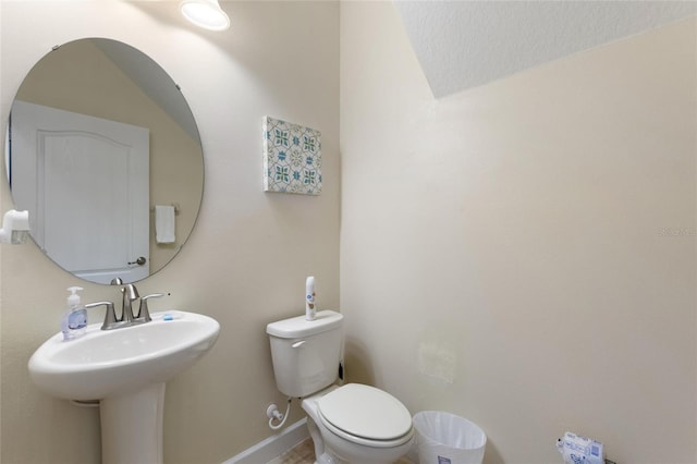 bathroom featuring a sink, toilet, and baseboards