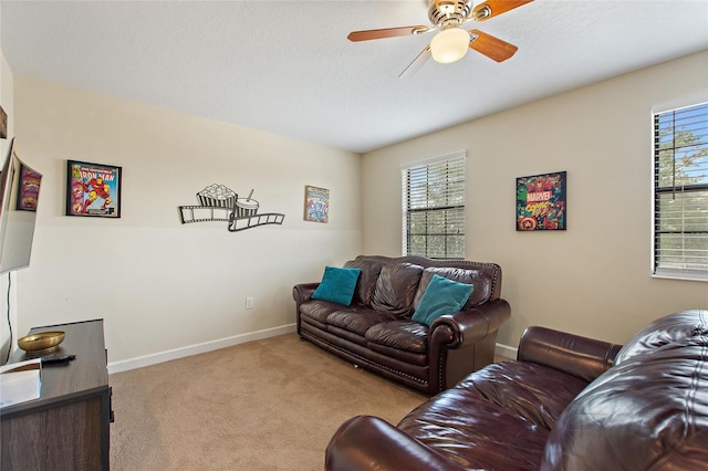 carpeted living room with ceiling fan and baseboards