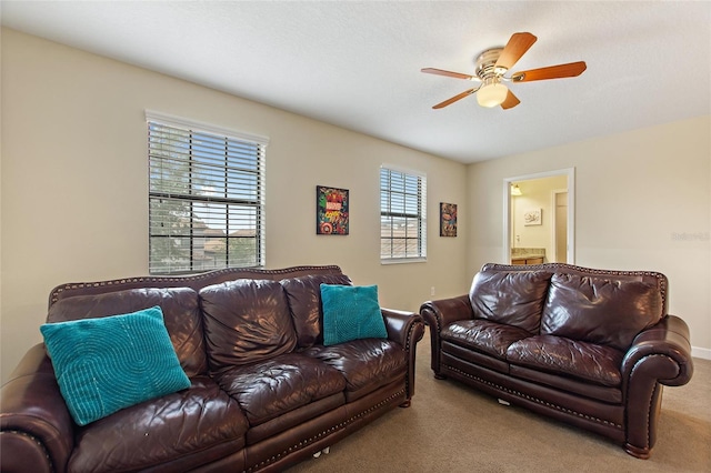 living area with ceiling fan, baseboards, and carpet floors
