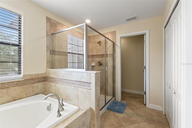 full bathroom with tile patterned flooring, a bath, baseboards, visible vents, and a stall shower