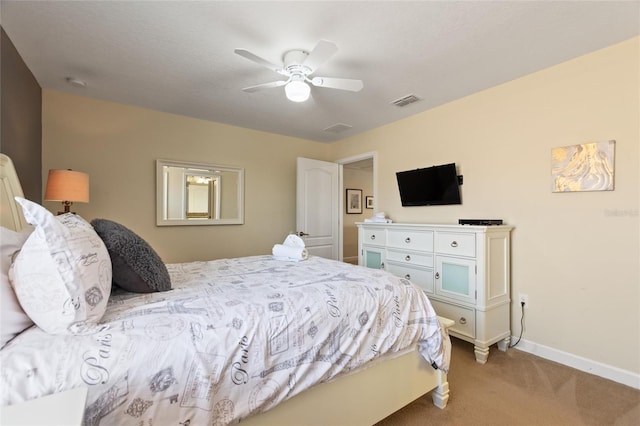 bedroom with light colored carpet, visible vents, a ceiling fan, and baseboards