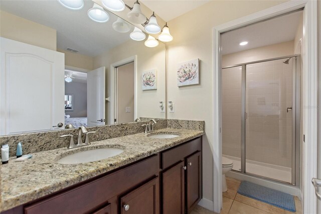 ensuite bathroom featuring toilet, tile patterned flooring, a sink, and visible vents