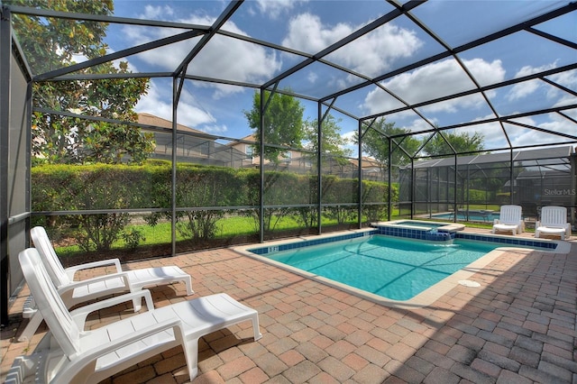 view of swimming pool featuring a patio, a lanai, and a pool with connected hot tub