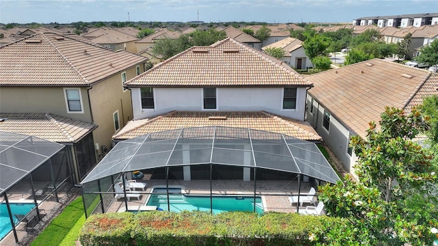back of house featuring a residential view, a patio, an outdoor pool, and a tiled roof