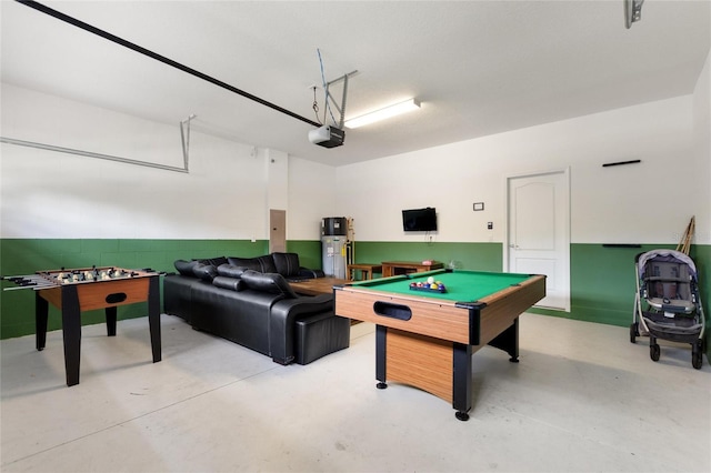 game room with heat pump water heater, billiards, concrete floors, and a garage