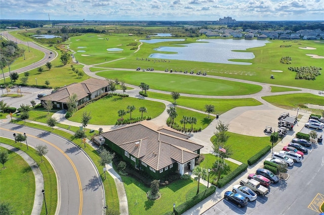 birds eye view of property with golf course view and a water view