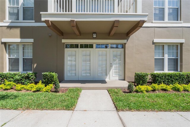 doorway to property with stucco siding and a balcony