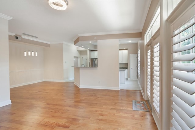 unfurnished living room featuring crown molding, baseboards, light wood-style flooring, and visible vents