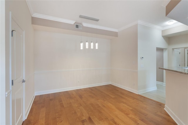 spare room featuring baseboards, ornamental molding, and light wood-style flooring