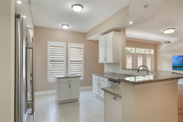kitchen featuring visible vents, a peninsula, baseboards, white cabinets, and appliances with stainless steel finishes