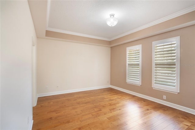unfurnished room with light wood-type flooring, ornamental molding, and baseboards