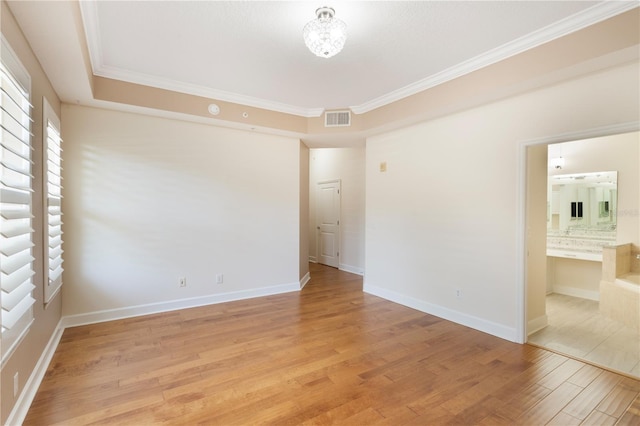 unfurnished room with baseboards, visible vents, ornamental molding, and light wood-style floors
