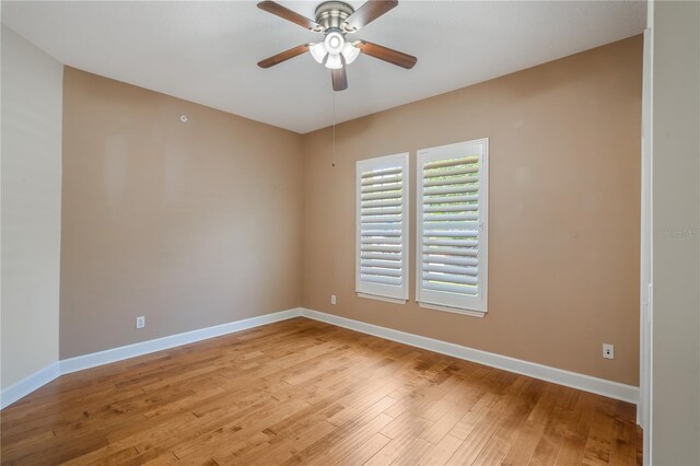 unfurnished room with baseboards, a ceiling fan, and light wood-style flooring