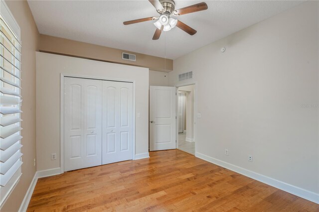 unfurnished bedroom featuring visible vents, light wood finished floors, baseboards, and a closet