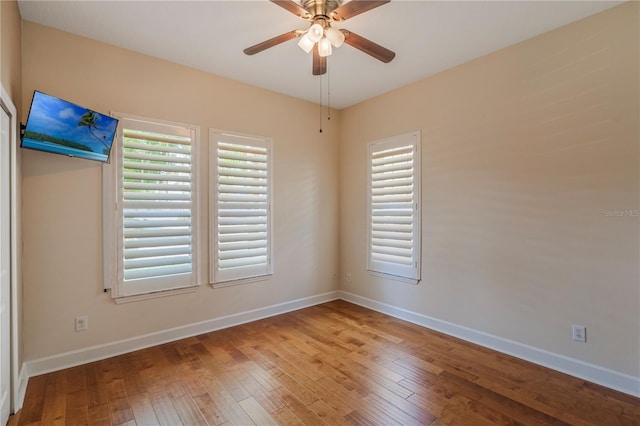 unfurnished room with baseboards, a ceiling fan, and hardwood / wood-style flooring