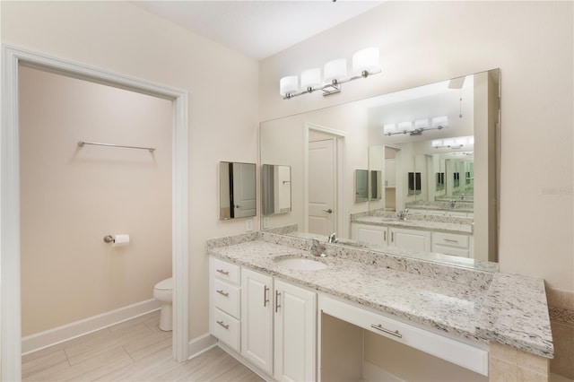 full bath with baseboards, toilet, and vanity