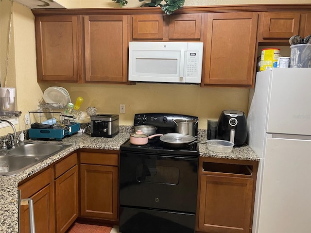 5501 Pga Blvd Unit 4714, Orlando, FL 32839 - kitchen with brown cabinets, white appliances, and a sink