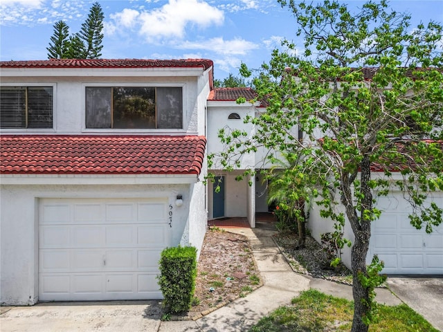 5077 Ernst Ct Unit 3, Orlando, FL 32819 - mediterranean / spanish-style home with a garage, stucco siding, and a tile roof