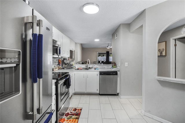 5077 Ernst Ct Unit 3, Orlando, FL 32819 - kitchen featuring appliances with stainless steel finishes, light countertops, white cabinets, ceiling fan, and a textured ceiling