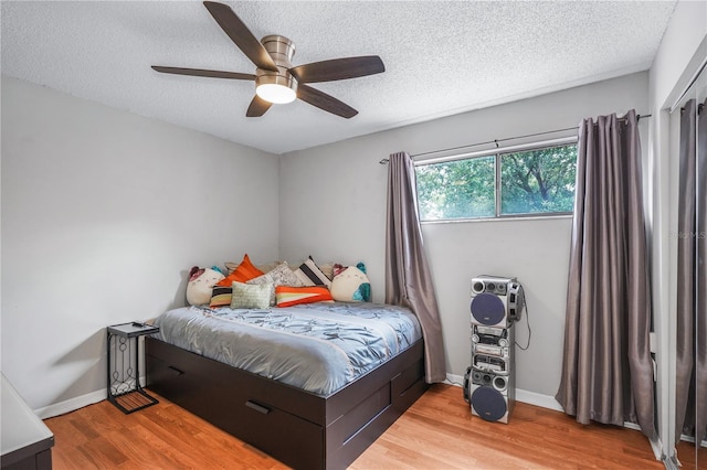 5077 Ernst Ct Unit 3, Orlando, FL 32819 - bedroom with baseboards, wood finished floors, a ceiling fan, and a textured ceiling