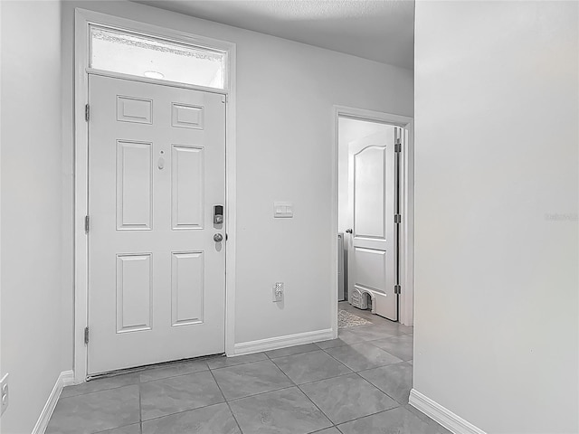 foyer with light tile patterned flooring and baseboards