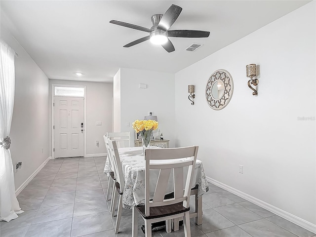 dining space featuring baseboards, visible vents, light tile patterned floors, and ceiling fan