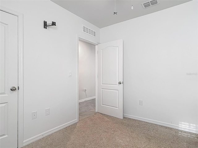 carpeted empty room with visible vents and baseboards