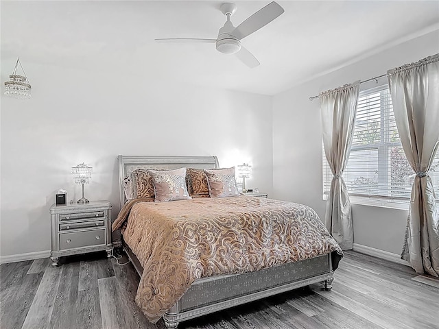 bedroom featuring wood finished floors, ceiling fan, and baseboards