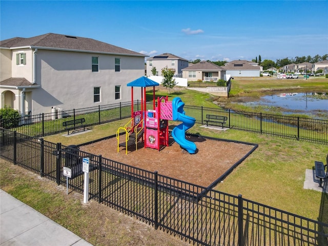 community play area with fence, a water view, a yard, and a residential view