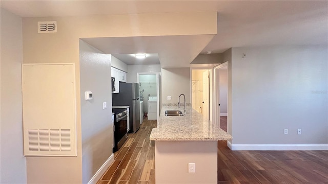 kitchen featuring a sink, visible vents, stainless steel appliances, baseboards, and dark wood finished floors