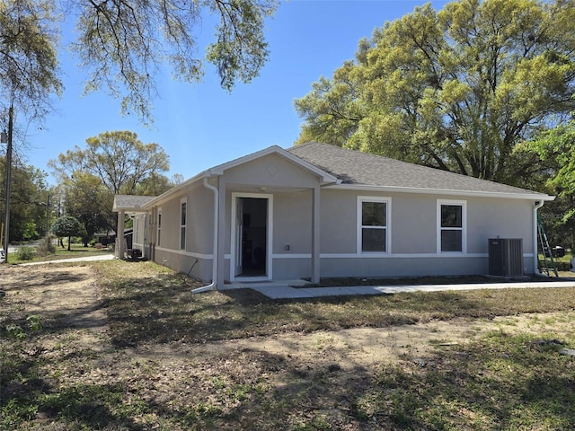 346 NW 24th Ave, Ocala, FL 34475 - view of front of house with stucco siding, central AC, and a shingled roof