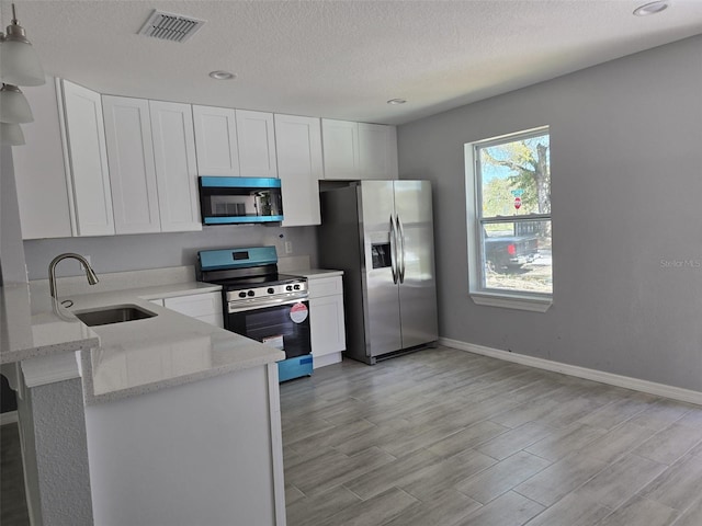346 NW 24th Ave, Ocala, FL 34475 - kitchen featuring a sink, white cabinets, light stone counters, and stainless steel appliances