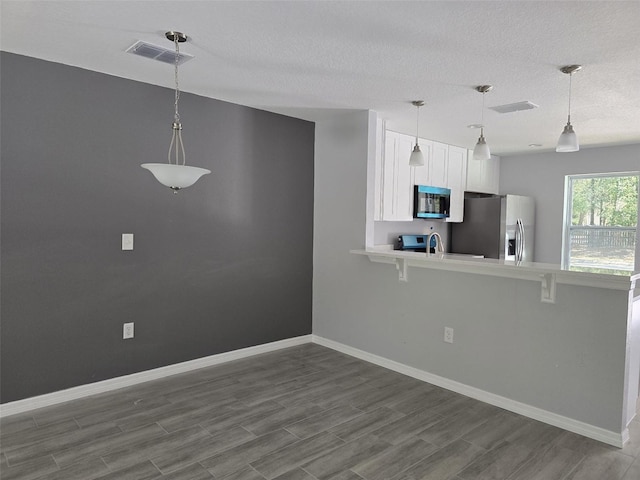 346 NW 24th Ave, Ocala, FL 34475 - kitchen with white cabinets, visible vents, stainless steel appliances, light countertops, and a peninsula