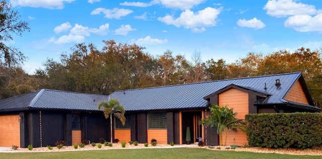 view of front of home featuring a standing seam roof, metal roof, and a front yard